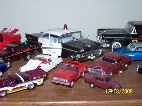 1972 Ford Ranchero - A collection of toy cars includes a black and white police car with 'Rye Police' text on its door.