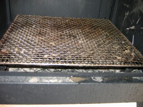 1992 Ford Bronco - Metal grill grate inside a smoker, showing ash and debris underneath.