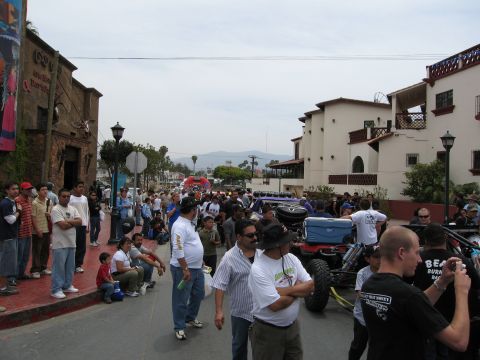 1986 Ford Bronco - A street scene with many people and off-road vehicles, possibly at an event.