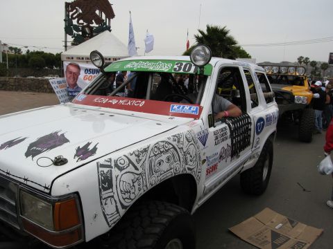 1986 Ford Bronco - This modified 1986 Ford Bronco features extensive custom graphics and off-road enhancements, seen here at an event.