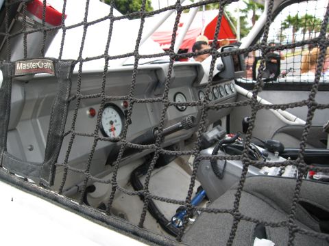 1986 Ford Bronco - The interior of a modified off-road vehicle, equipped with racing seats and safety netting, is viewed through a protective net.