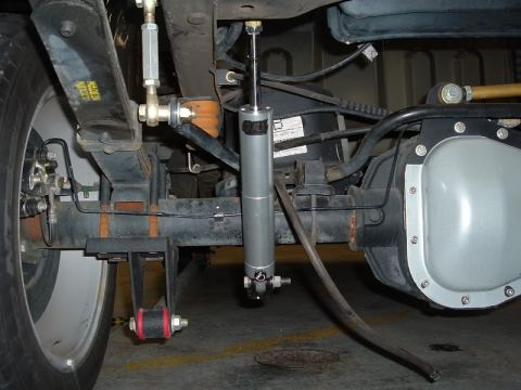 2007 Ford Mustang - Close-up view of a vehicle's rear suspension system, including the shock absorber, leaf spring, and differential housing.