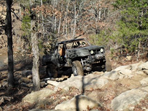 1986 Ford Bronco - This heavily modified off-road vehicle navigates a challenging rocky terrain.