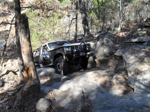 1986 Ford Bronco - A modified Ford Bronco navigates a rocky trail, demonstrating its off-road capabilities.