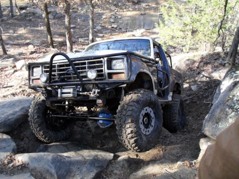 1986 Ford Bronco - This heavily modified Ford Bronco is shown tackling a challenging off-road course.