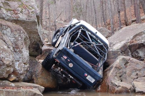 1986 Ford Bronco - A modified 1986 Ford Bronco navigates a rocky stream bed during an off-road excursion.