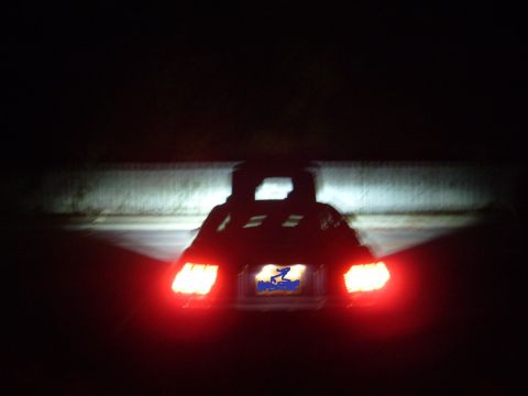 1992 Ford Bronco - Vehicle's taillights are on at night, showing the rear of the car.