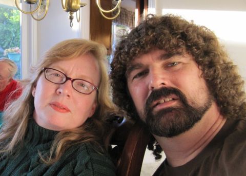 1990 Ford Bronco - A woman wearing glasses and a dark green sweater poses with a man who has curly hair and a beard.