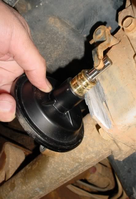 2007 Ford Mustang - A hand holds a component near a rusty, possibly mechanical, assembly.