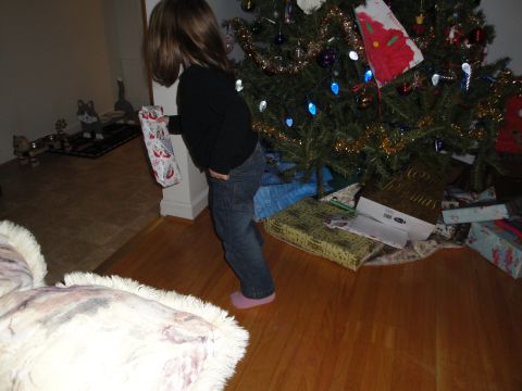 2000 Ford Crown Victoria - A child stands by a Christmas tree, holding a gift, with presents scattered around the base.
