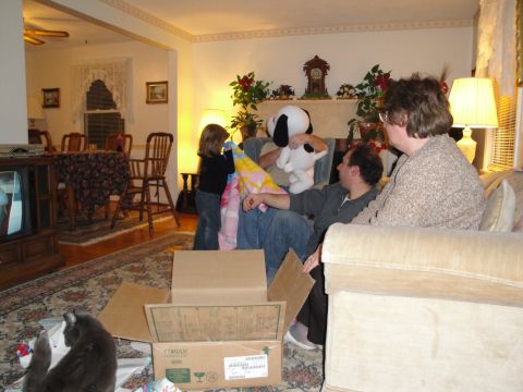 2000 Ford Crown Victoria - Family gathering in a living room, opening presents with a cat nearby.