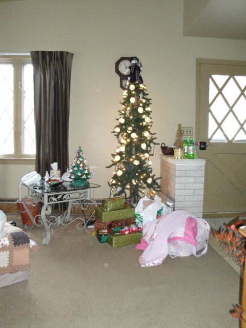 2000 Ford Crown Victoria - A festive living room scene with a decorated Christmas tree and presents piled on the floor.