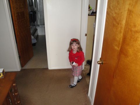 2000 Ford Crown Victoria - A young child stands in a hallway, looking towards the camera, with doorways to a bathroom and another room visible.