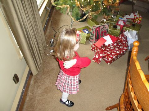 2000 Ford Crown Victoria - A young child stands near a decorated Christmas tree surrounded by wrapped presents.