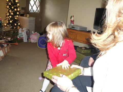 2000 Ford Crown Victoria - A child eagerly unwraps a present on Christmas morning, surrounded by festive decorations.