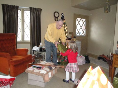 2000 Ford Crown Victoria - A grandfather and child exchange gifts during the holidays in a decorated living room.