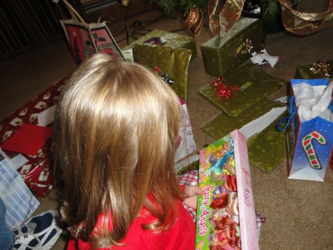 2000 Ford Crown Victoria - A child excitedly opens a gift box filled with fairy angel dolls, surrounded by wrapped presents.
