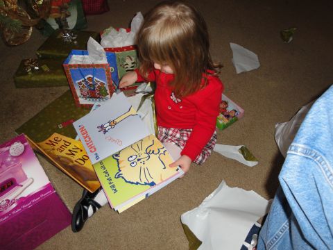 2000 Ford Crown Victoria - A child sits on the floor surrounded by Christmas presents, opening books.
