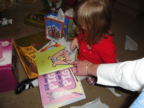 2000 Ford Crown Victoria - A child is excitedly opening presents and books on the floor.
