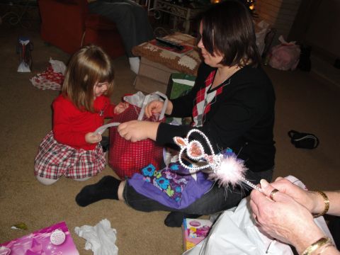 2000 Ford Crown Victoria - A child and adults are opening presents on the floor, with a wand visible.