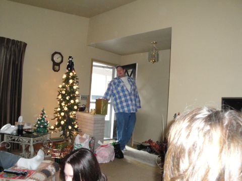 2000 Ford Crown Victoria - A man holds a gift while standing in a doorway during a holiday gathering.