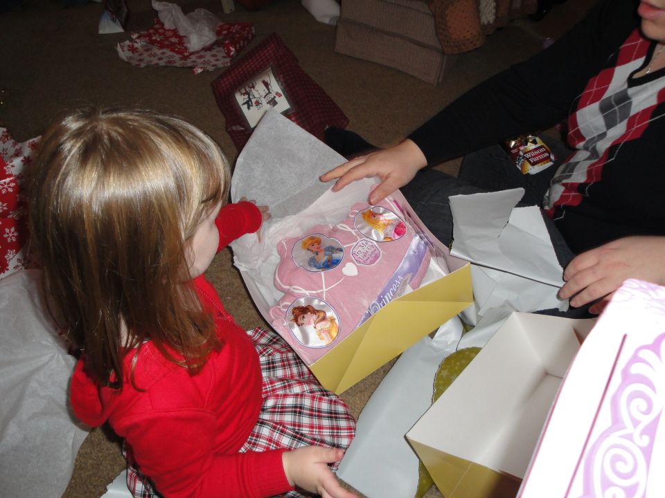 Child opening a pink princess toy with Disney characters