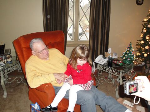 2000 Ford Crown Victoria - A man and a young child are seated in a living room, with a Christmas tree visible.