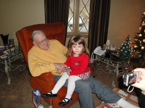 2000 Ford Crown Victoria - A man and a young child sit together in a chair, with a decorated Christmas tree visible in the background.