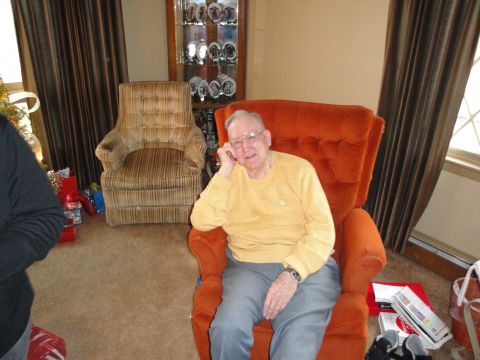 2000 Ford Crown Victoria - An elderly man relaxes in an armchair in a living room setting, with holiday decorations visible.