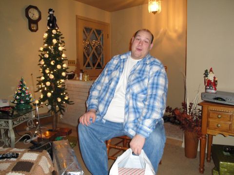 2000 Ford Crown Victoria - A man sits in a chair in a room decorated for the holidays, with a Christmas tree and festive items visible.