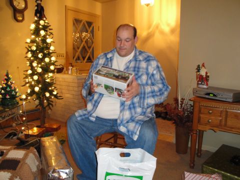 2000 Ford Crown Victoria - Man holding a model car box in a room decorated for Christmas.
