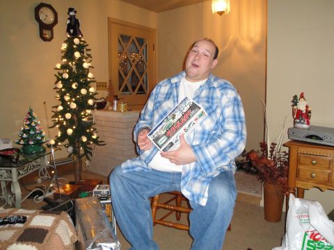 2000 Ford Crown Victoria - A man sits in a room decorated for Christmas, holding a box of model cars.