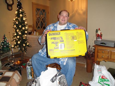 2000 Ford Crown Victoria - A man sits in a room decorated for Christmas, holding a DeWalt tool case.