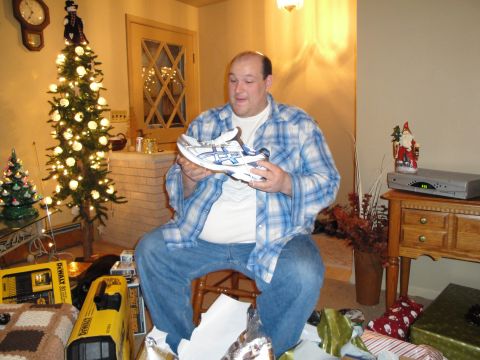 2000 Ford Crown Victoria - Man receives running shoes as a Christmas gift, surrounded by presents and holiday decorations.