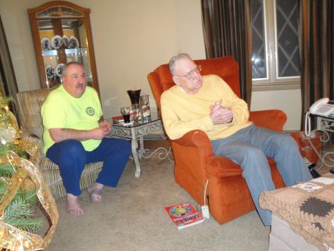 2000 Ford Crown Victoria - Two men relax in a living room setting, with a Christmas tree visible on the left.