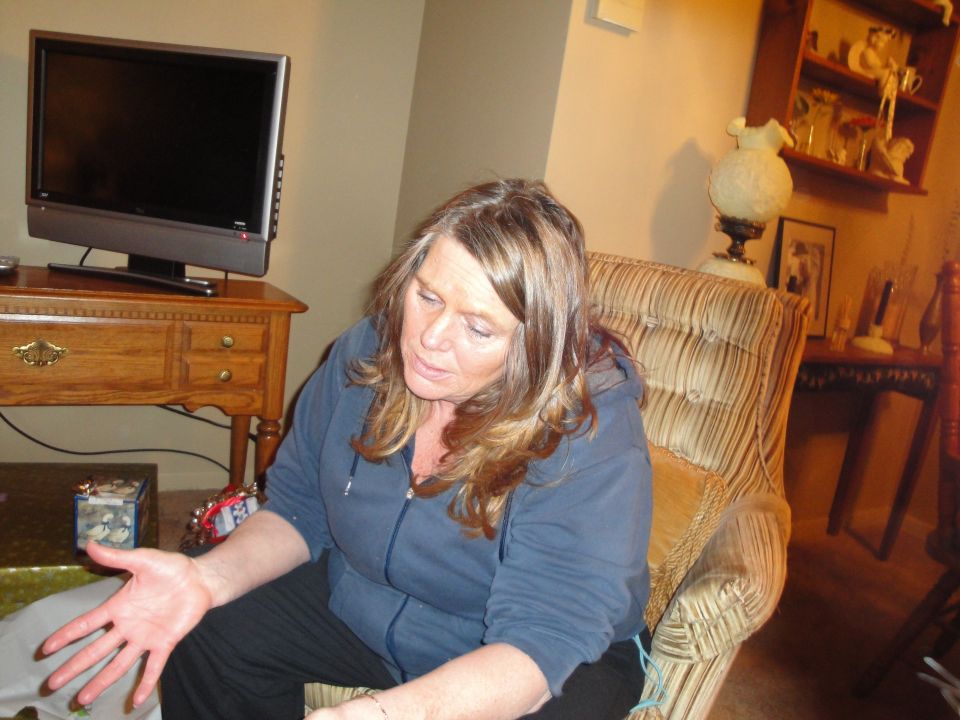 Woman sitting in a chair, looking down