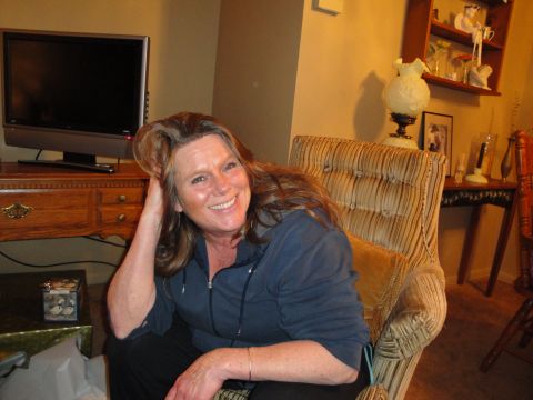 2000 Ford Crown Victoria - A woman smiles for the camera while relaxing in a chair in a living room setting.