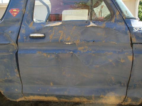 1979 Ford Bronco - This heavily damaged blue SUV, possibly a 1978 model, is covered in mud and has a Superman logo on its side.