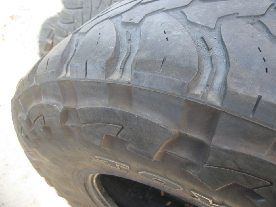 Tire tread with large, aggressive blocks and sipes, showing some wear