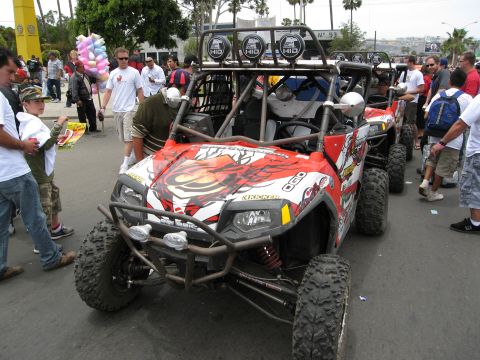 1986 Ford Bronco - Several off-road vehicles are lined up, with people milling around them.