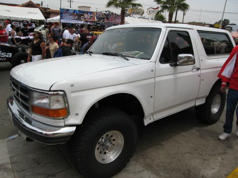 1986 Ford Bronco - White 1992 Ford Bronco with aftermarket wheels and tires is parked outdoors.