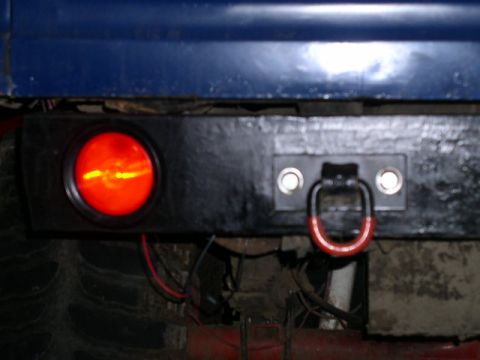 1979 Ford Bronco - Close-up of a vehicle's rear bumper, showing a tow hook and a red taillight.