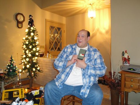 2000 Ford Crown Victoria - A man sits in a chair holding a gift in a room decorated for Christmas.