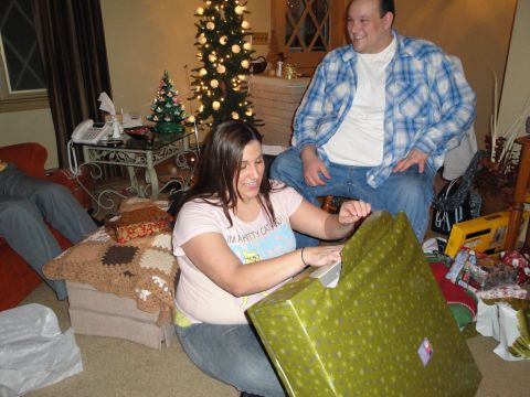 2000 Ford Crown Victoria - A festive scene unfolds as individuals eagerly unwrap gifts around a Christmas tree.