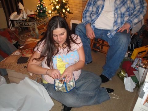 2000 Ford Crown Victoria - People are opening gifts in a living room decorated for Christmas.