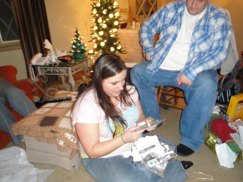 2000 Ford Crown Victoria - A holiday gathering with people opening presents in a decorated living room.