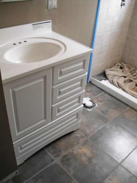 1991 Ford Bronco - A white bathroom vanity with a sink is positioned next to a tiled shower stall, indicating ongoing renovation or upgrades.