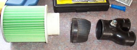 1990 Ford Bronco - Left: a cheap ($10) Fram filter from Autozone, in the middle a piece of rubber hose cut from my old '90 setup, on the right a factory "Y" f…