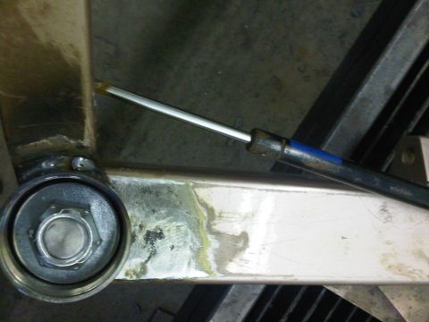 1996 Ford Bronco - Close-up view of a gas strut and its mounting hardware on a metal frame.