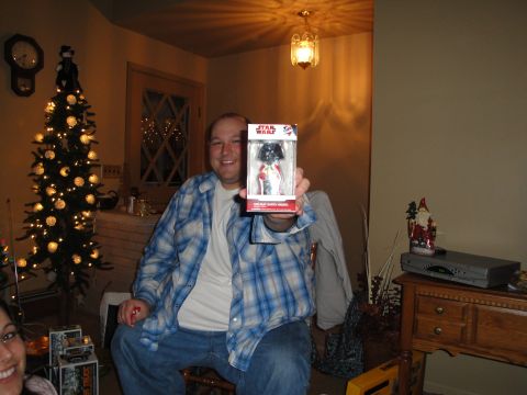 2000 Ford Crown Victoria - Man holds a Star Wars toy in front of a decorated Christmas tree.